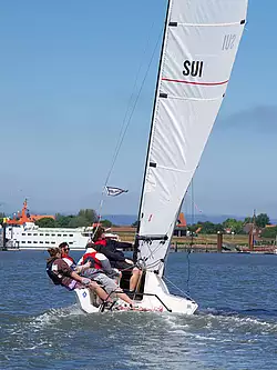 Vier Schüler segeln mit einer Beneteau First 18 in Richtung des Spiekerooger Hafens.